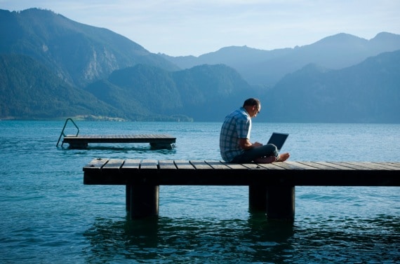 Man Sitting on a Dock with a Laptop - Photo courtesy of ©iStockphoto.com/Claudiad, Image #10484365